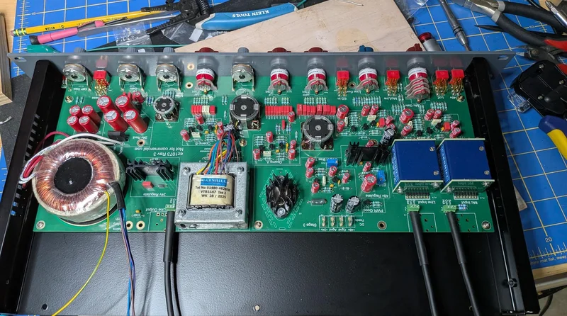 Close-up of the EZ1073 circuit board mid-assembly, populated with Carnhill iron, Grayhill switches, and tidy solder work across the audio path.